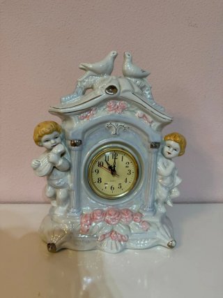Reloj de cerámica antiguo con querubines
