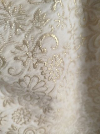 Vestido de fiesta beige con detalles dorados.