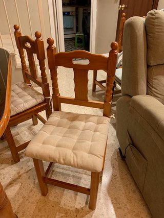 Mesa de salón con vidrio y sillas.