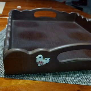 Vassoio in legno scuro con decorazioni