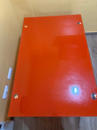 Mesa cristal naranja y patas grises