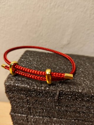Pulsera hilo rojo con detalles dorados