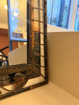 Specchio con cornice in metallo decorata