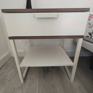 Mesita de noche Ikea blanca con bordes de madera.