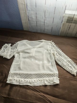 Blusa blanca con transparencias y pompón
