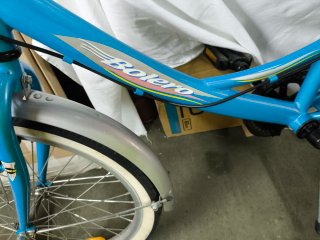 Bicicleta azul con portabultos y guardabarros.