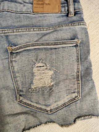 Pantalones cortos vaqueros desgastados de niña