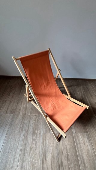 Tumbona de tela y madera naranja para jardín.