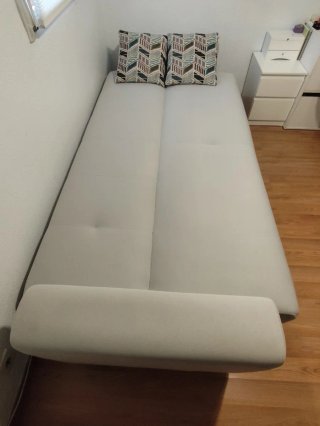 Sofá cama beige con cojines