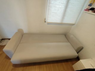Sofá cama beige con cojines