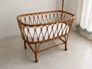 Moises de bebé con un diseño natural en ratán.