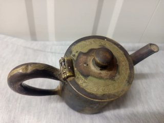 Tetera antigua de metal con grabado