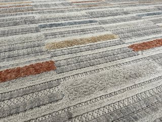 Alfombra de tela beige, gris y naranja