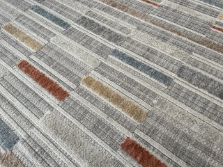 Alfombra de tela beige, gris y naranja
