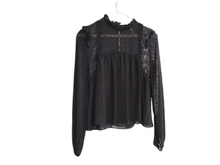 Blusa negra con transparencias y volantes