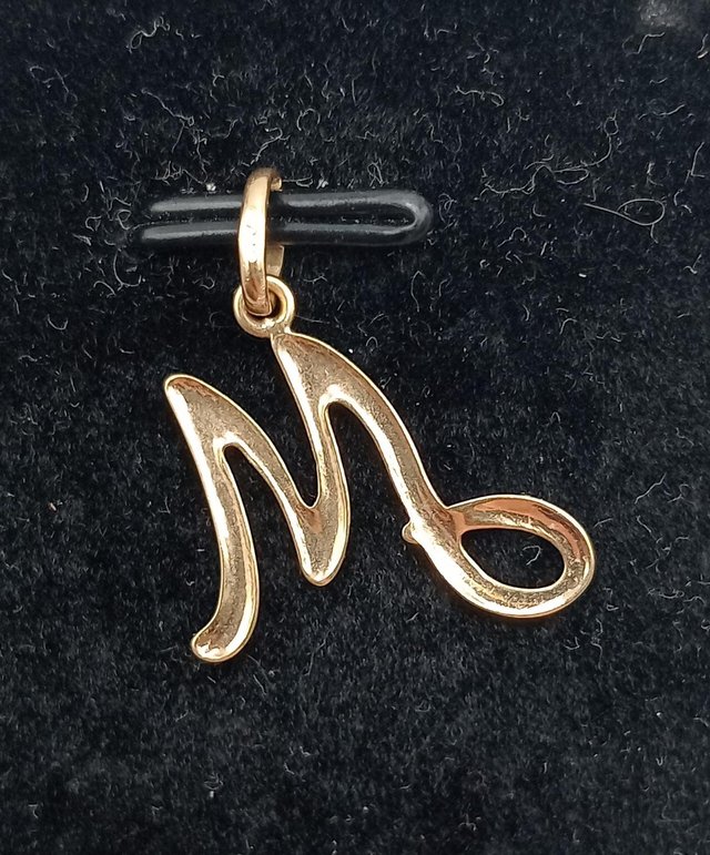 Colgante Letra “M” de oro 18k, 0,62gr, Ref. O-406.