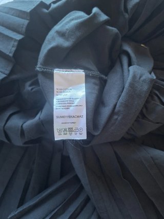 Vestido negro con capucha y plisados