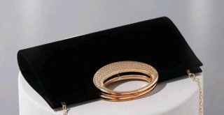 Bolso de mano negro de terciopelo con asa dorada