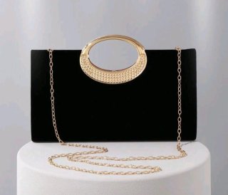 Bolso de mano negro de terciopelo con asa dorada
