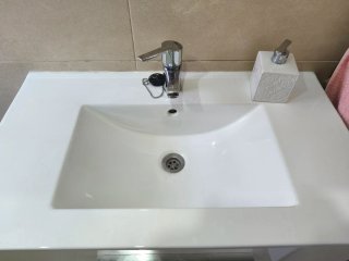Mueble baño suspendido con lavabo, grifo y espejo.