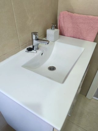 Mueble baño suspendido con lavabo, grifo y espejo.