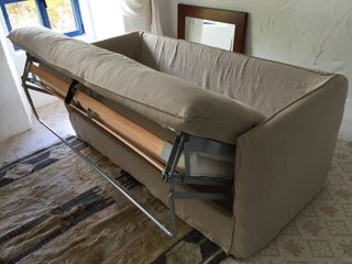 Sofá cama beige de tela con cojines