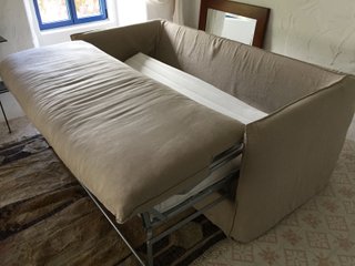 Sofá cama beige de tela con cojines