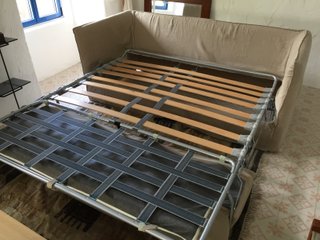 Sofá cama beige de tela con cojines
