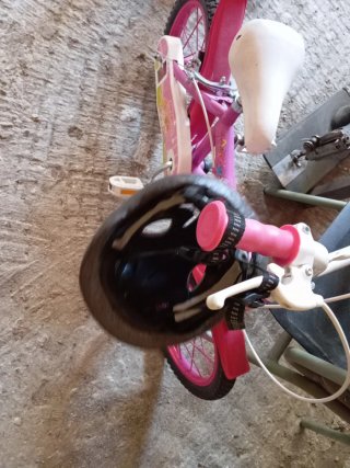 Bicicleta infantil rosa con casco