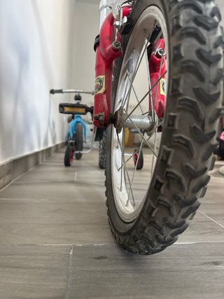 Bicicleta infantil roja con ruedines
