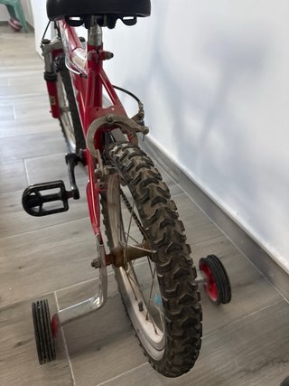 Bicicleta infantil roja con ruedines
