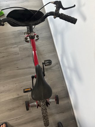 Bicicleta infantil roja con ruedines