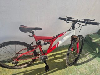 Bicicleta de montaña roja y blanca para reparar