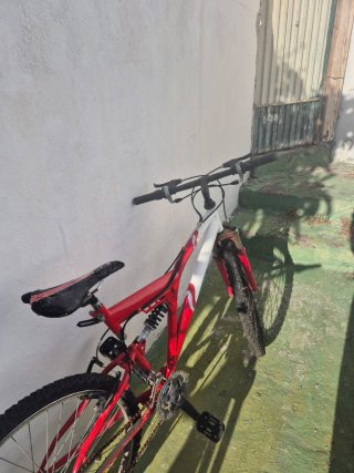 Bicicleta de montaña roja y blanca para reparar