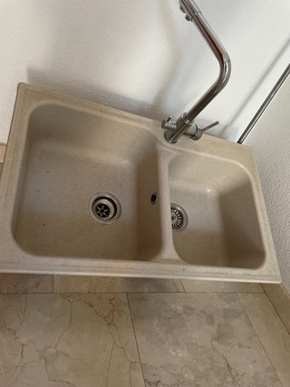 Fregadero doble beige y grifo plateado