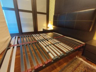 Dormitorio con cabecero, mesillas y cómoda.