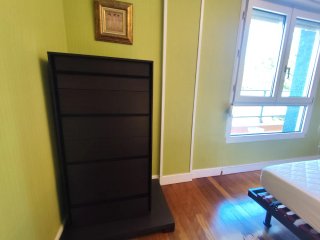 Dormitorio con cabecero, mesillas y cómoda.
