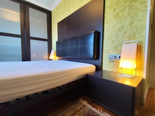 Dormitorio con cabecero, mesillas y cómoda.