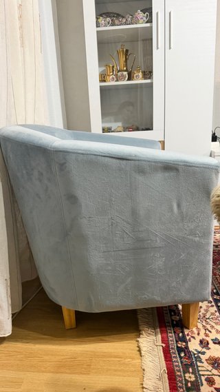 Sillón de tela azul con patas de madera