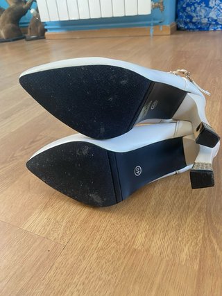 Zapatos de tacón blancos y dorados