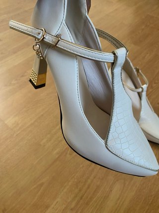 Zapatos de tacón blancos y dorados