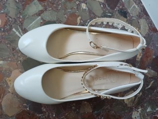 Zapatos blancos con correa y adornos dorados