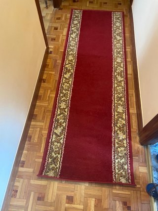 Alfombra de pasillo roja con bordes dorados