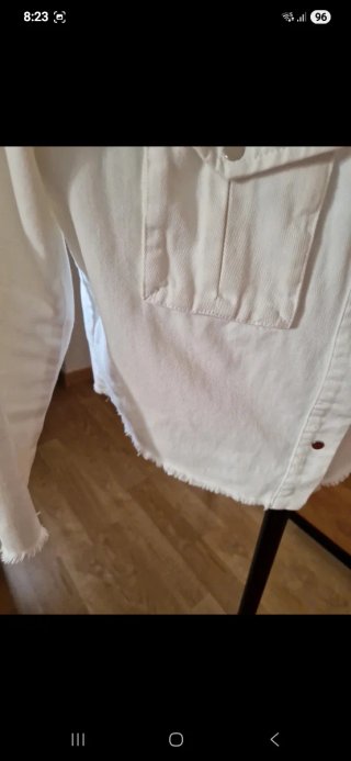 Chaqueta vaquera corta color blanco crudo.