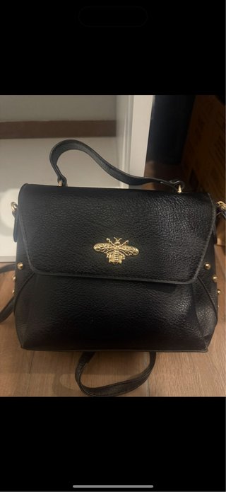 Bolso negro con detalle de abeja dorada