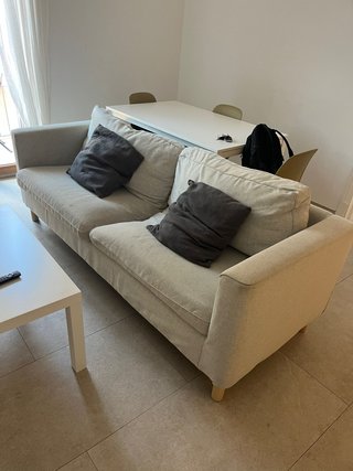 Sofá beige con cojín