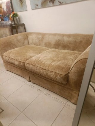 Sofá tapizado en tèxtil beige. Incluye cojines.