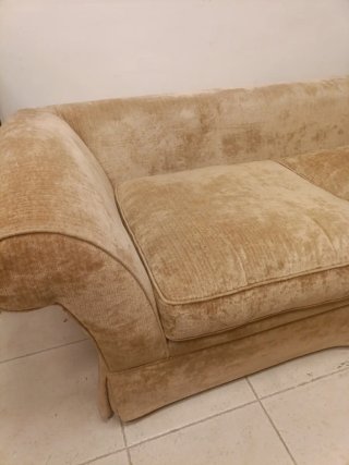 Sofá tapizado en tèxtil beige. Incluye cojines.