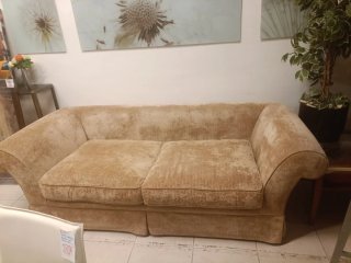 Sofá tapizado en tèxtil beige. Incluye cojines.