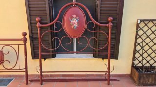 Letto in ferro battuto con decorazioni floreali